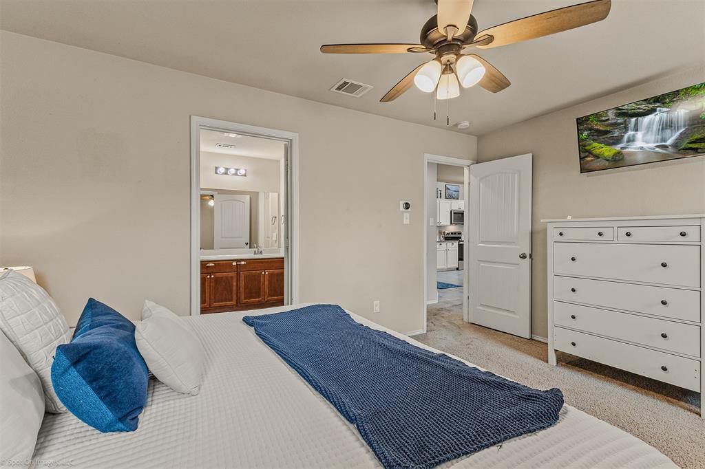 2440 Willard Way Forney, TX 75126 - Photo 14 of 25 a spacious bedroom with a bed and a chandelier