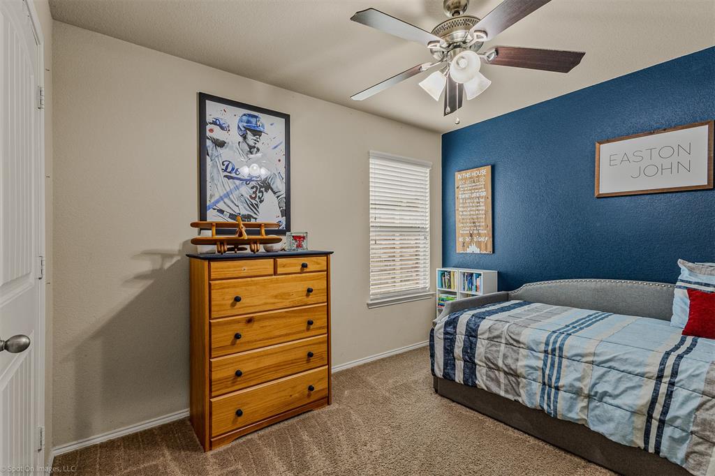 2440 Willard Way Forney, TX 75126 - Photo 18 of 25 a bedroom with a bed and a chandelier