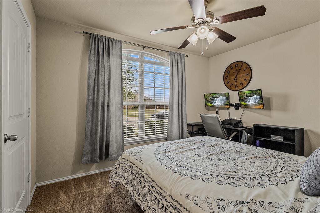 2440 Willard Way Forney, TX 75126 - Photo 21 of 25 a bedroom with a bed a chandelier and a window