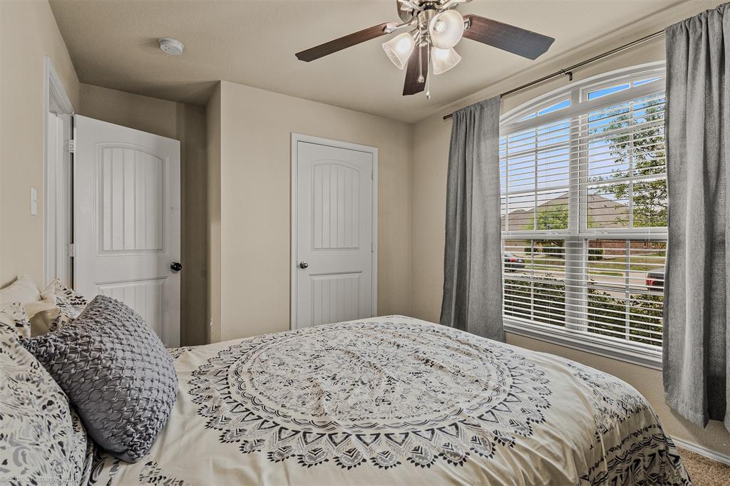 2440 Willard Way Forney, TX 75126 - Photo 22 of 25 a bedroom with a large bed and a chandelier