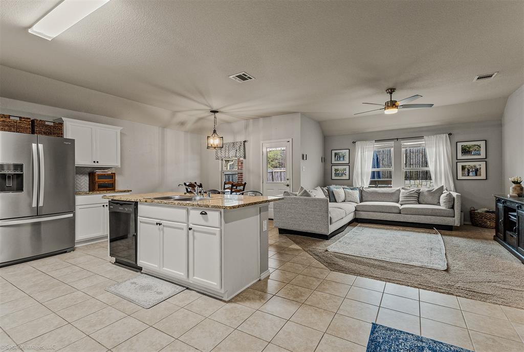 2440 Willard Way Forney, TX 75126 - Photo 6 of 25 a large white open kitchen with cabinets and stainless steel appliances