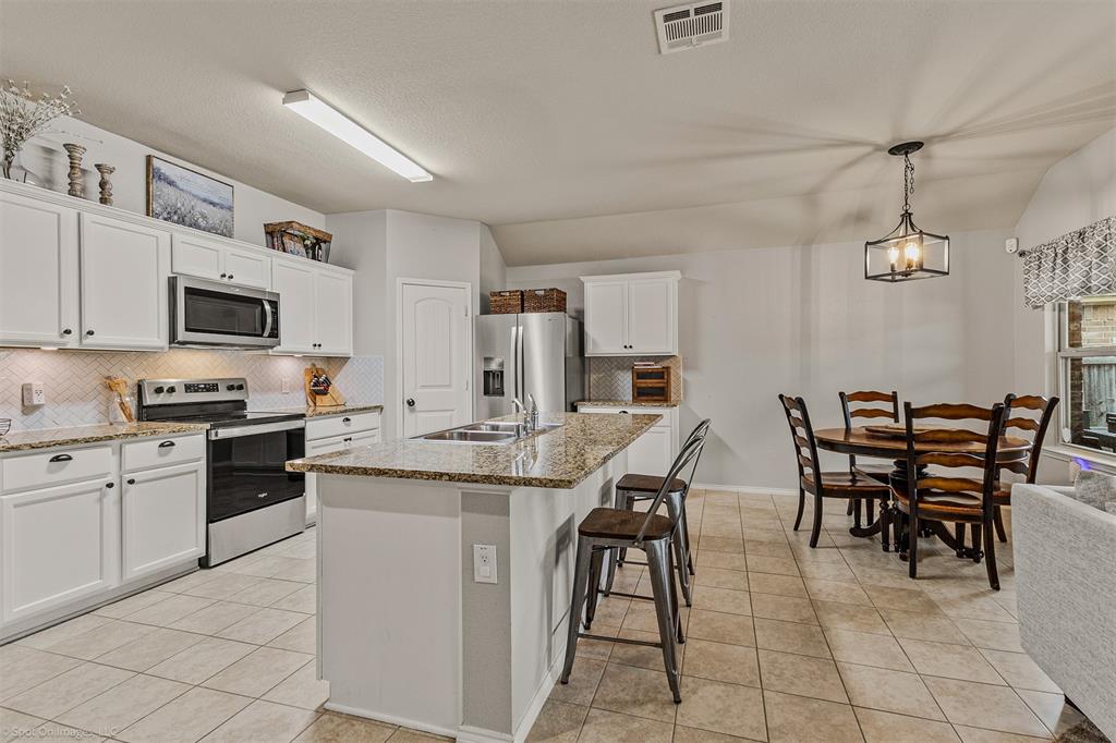 2440 Willard Way Forney, TX 75126 - Photo 10 of 25 a kitchen with appliances cabinets and chairs
