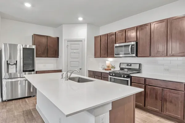 a kitchen with kitchen island a sink stove and refrigerator