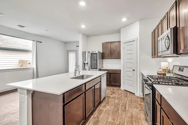 a kitchen with a sink stove and refrigerator
