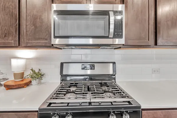 a stove top oven sitting inside of a kitchen
