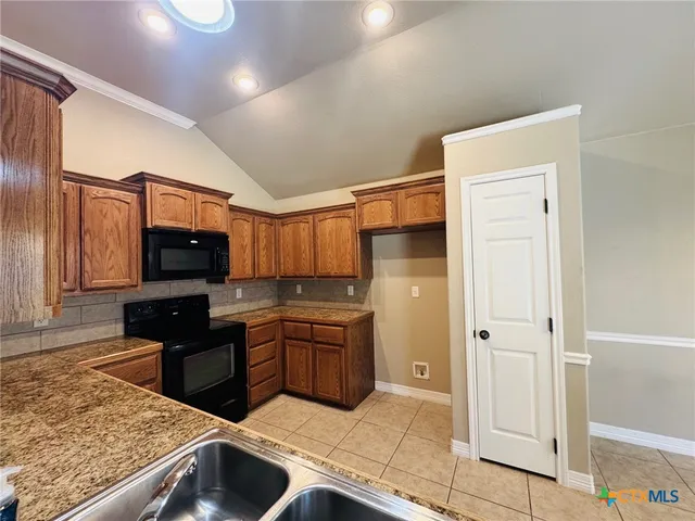 a kitchen with stainless steel appliances granite countertop a refrigerator and a sink