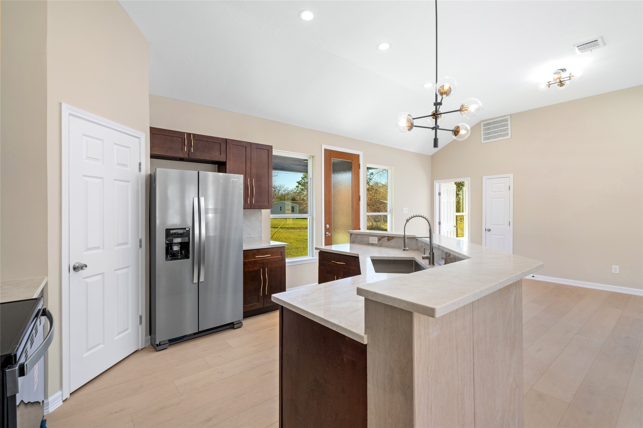 4654 North Teague Street Rosharon, TX 77583 - Photo 19 of 46 A wide-angle captures the full
kitchen layout, including
generous storage, elegant
finishes, and a seamless
connection to living and
dining areas.