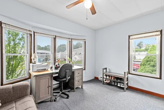 a view of a livingroom with workspace and a window