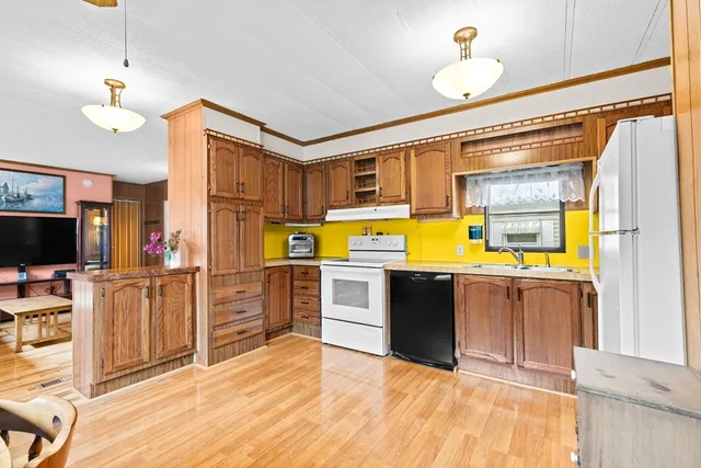 a kitchen with stainless steel appliances kitchen island granite countertop a refrigerator and a stove top oven