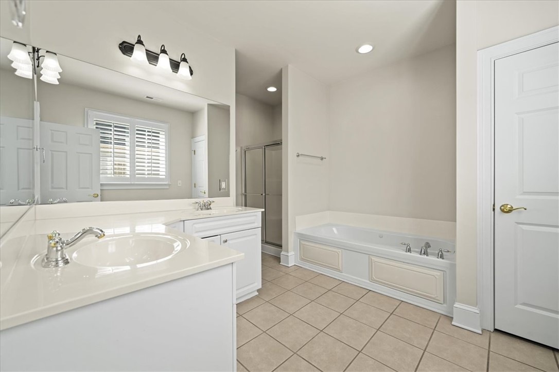 38 Angus Run Seneca, SC 29672 - Photo 31 of 46 This bright bathroom features dual vanities, a separate tub, and a shower, all complemented by clean tile flooring.