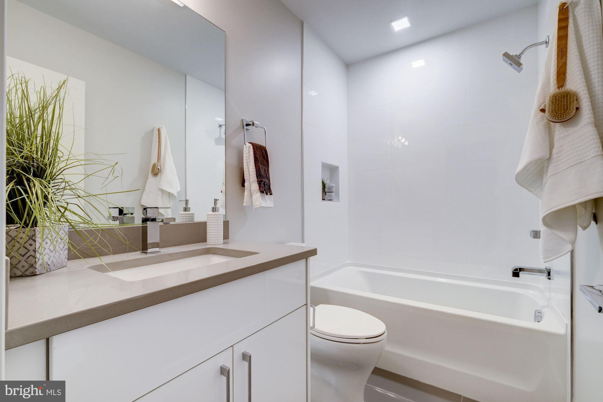 1331 K Street Southeast, Unit 302 Washington, DC 20003 - Photo 5 of 13 a bathroom with a granite countertop sink toilet and shower