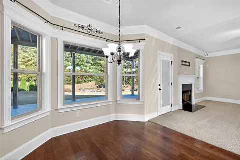 a view of a room with window wooden floor ceiling fan and windows