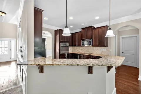 a kitchen with stainless steel appliances granite countertop wooden cabinets a sink and a granite counter tops