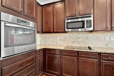a kitchen with granite countertop cabinets stainless steel appliances and a counter space