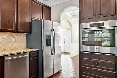 a kitchen with stainless steel appliances granite countertop a refrigerator and a stove top oven