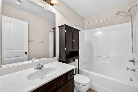 a bathroom with a sink toilet double vanity and shower