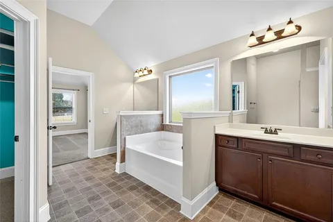 a bathroom with a tub sink and mirror