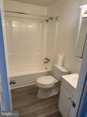a white toilet sitting next to a bath tub