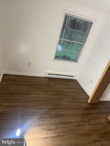 a view of a room with wooden floor and a window