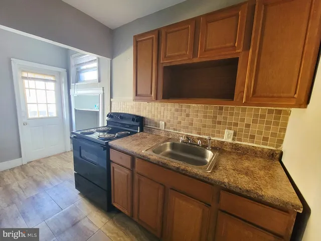 a kitchen with granite countertop stainless steel appliances a stove sink and microwave