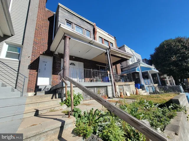 a view of a house with large windows and a small yard