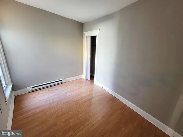 an empty room with wooden floor and closet