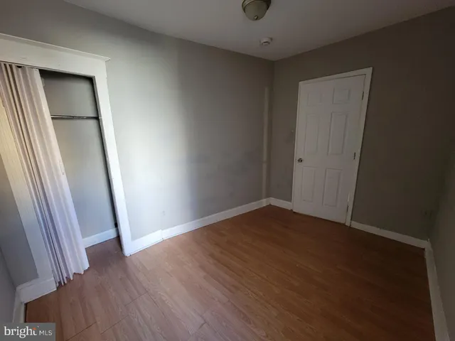 an empty room with wooden floor and entrance