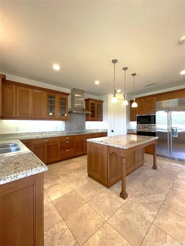 a large kitchen with kitchen island a stove a sink a counter space and cabinets