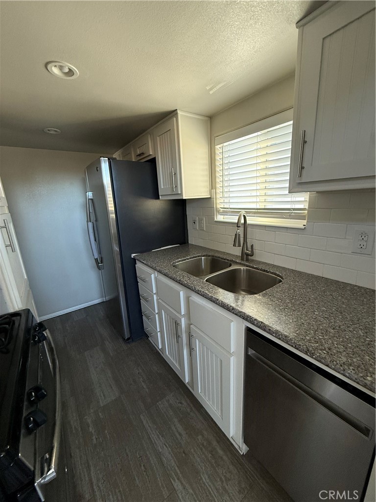 4849 Peck Road, Unit 67 El Monte, CA 91732 - Photo 6 of 13 a kitchen with stainless steel appliances granite countertop a sink stove and refrigerator