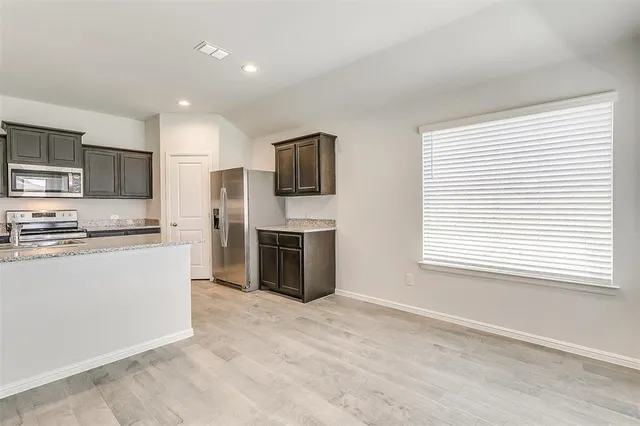 a kitchen with stainless steel appliances a refrigerator sink and microwave