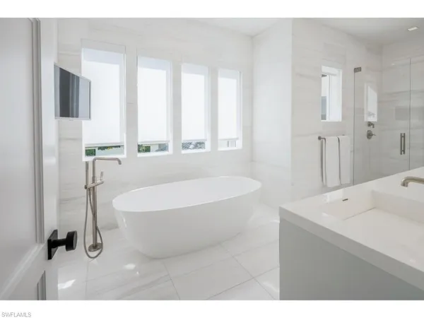 a spacious bathroom with a bathtub sink and mirror