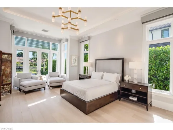 a bedroom with a bed couch and a large window