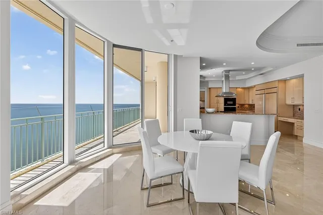 a dining room with furniture and large windows