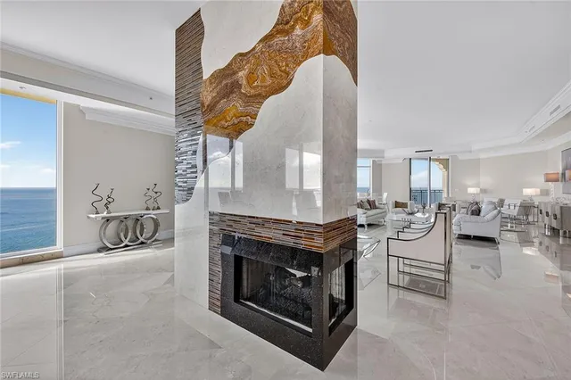 a living room with furniture a fireplace and a dining table with wooden floor