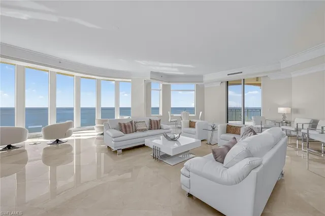 a living room with furniture and large windows