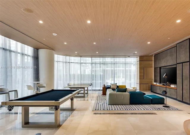 a living room with furniture a flat screen tv and a large window