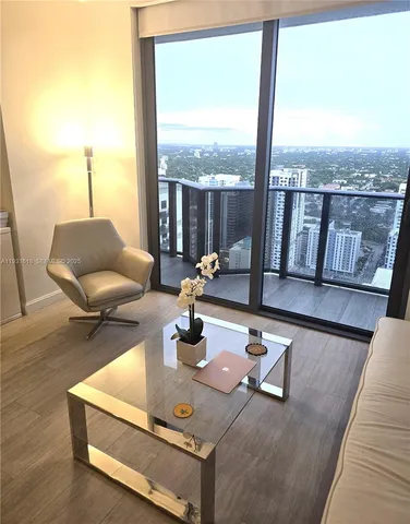 a living room with furniture and floor to ceiling windows