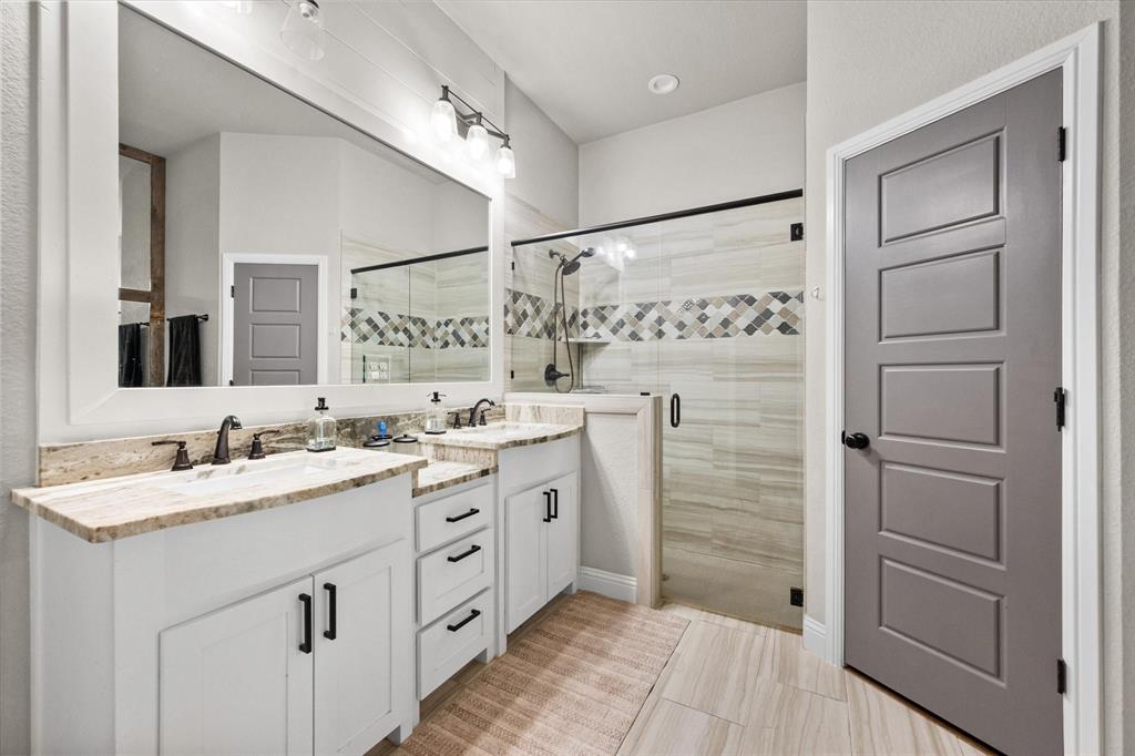 6365 Rhoden Avenue Godley, TX 76044 - Photo 17 of 31 a bathroom with a double vanity sink a mirror and a shower