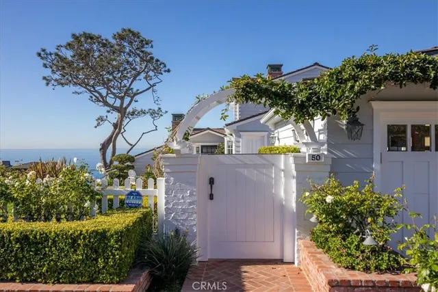 a front view of a house with a garden and trees