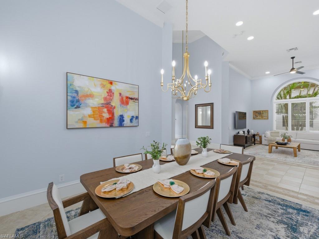 18091 Lagos Way Naples, FL 34110 - Photo 11 of 50 a view of a dining room with furniture a chandelier and wooden floor