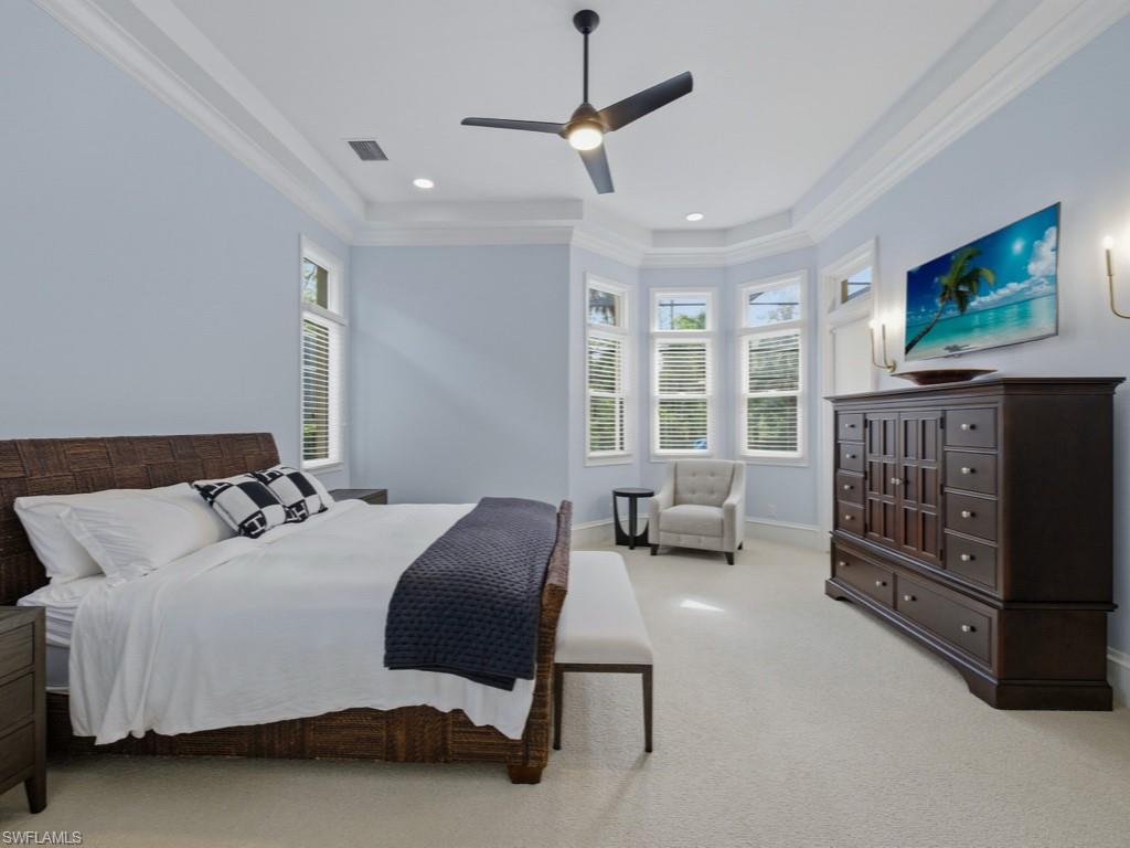 18091 Lagos Way Naples, FL 34110 - Photo 12 of 50 a bedroom with a bed a couch and a flat tv screen
