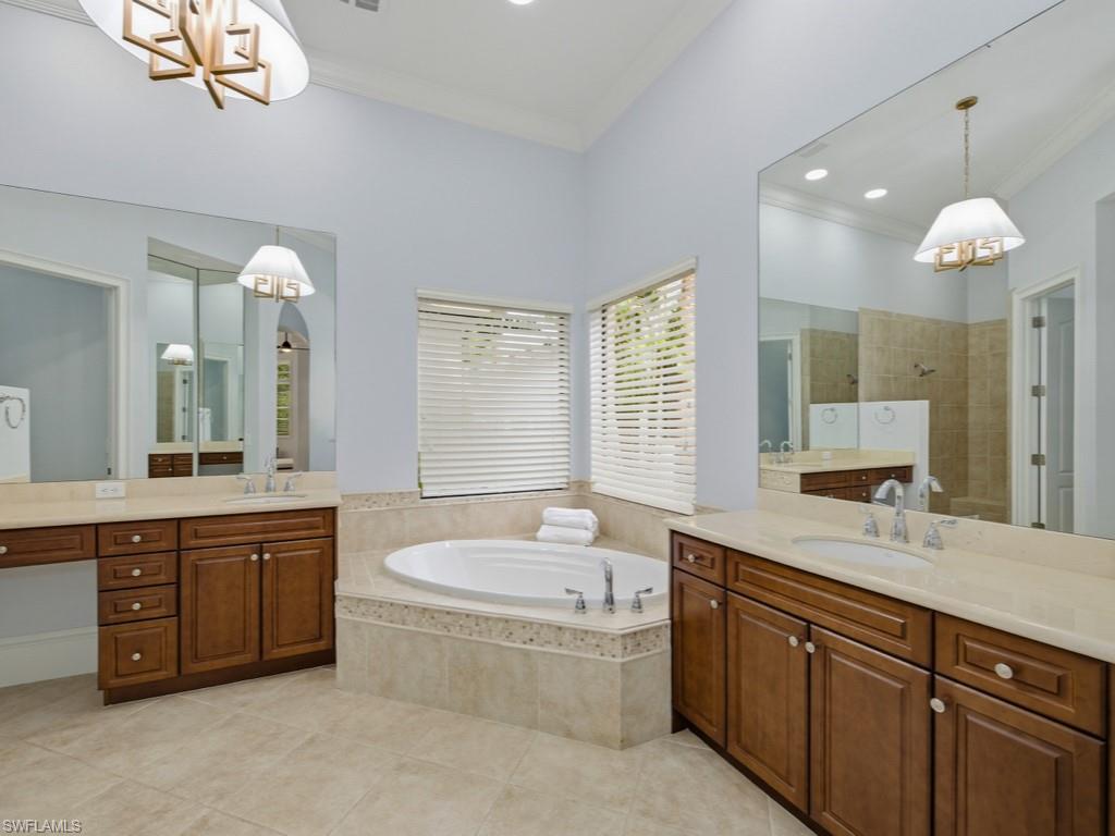 18091 Lagos Way Naples, FL 34110 - Photo 13 of 50 a spacious bathroom with a tub sink and a mirror