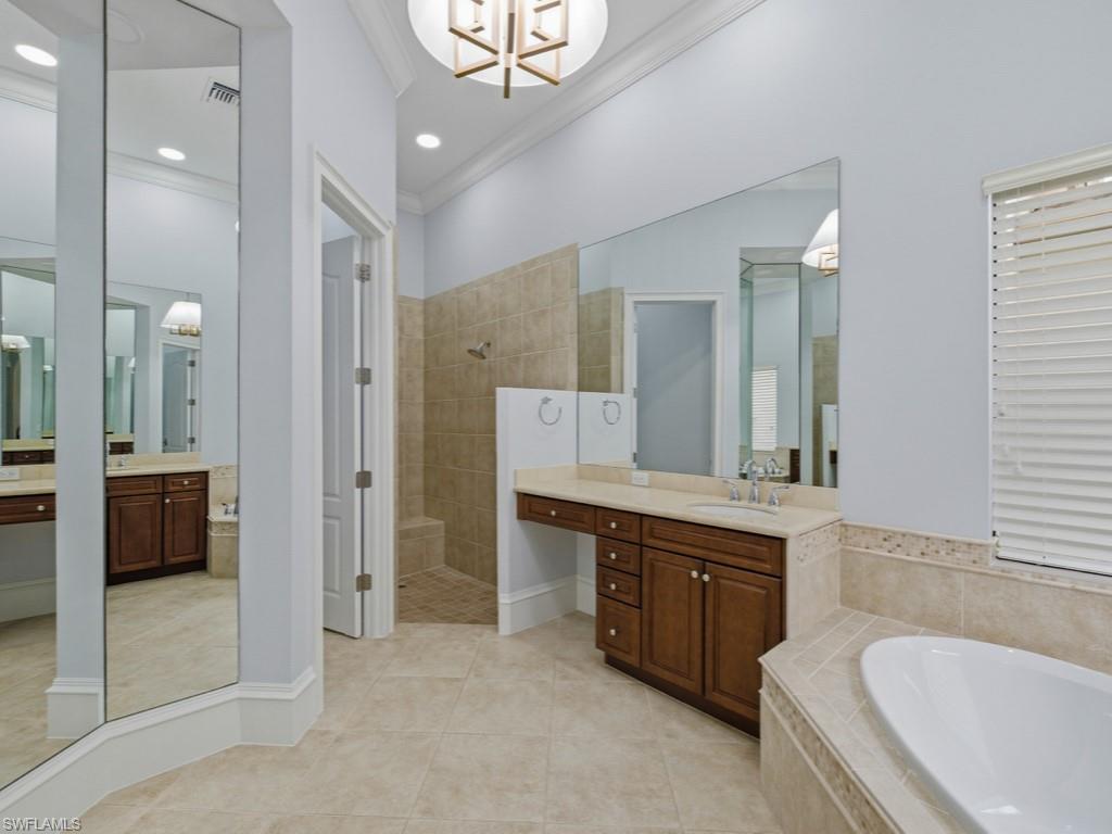 18091 Lagos Way Naples, FL 34110 - Photo 14 of 50 a spacious bathroom with a granite countertop tub double vanity and a mirror