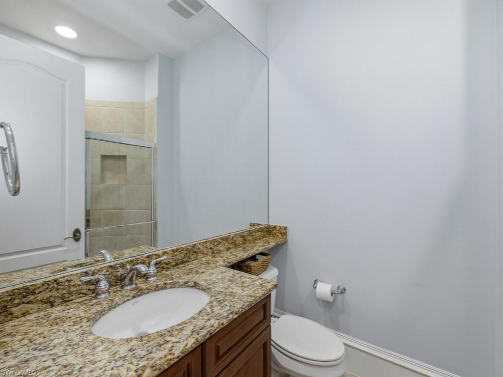 18091 Lagos Way Naples, FL 34110 - Photo 16 of 50 a bathroom with a granite countertop sink toilet and mirror