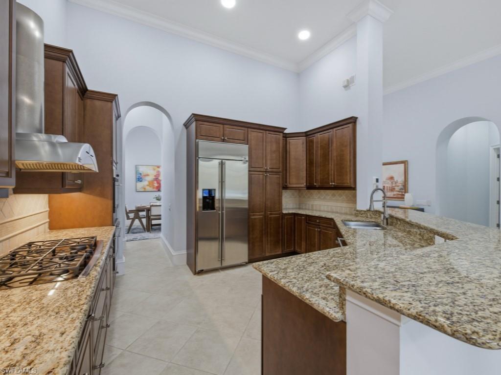 18091 Lagos Way Naples, FL 34110 - Photo 9 of 50 a kitchen with stainless steel appliances granite countertop a sink stove and refrigerator