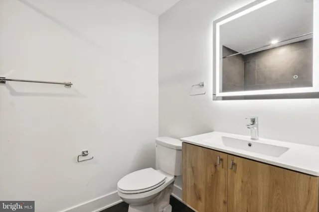 a bathroom with a sink mirror vanity and toilet