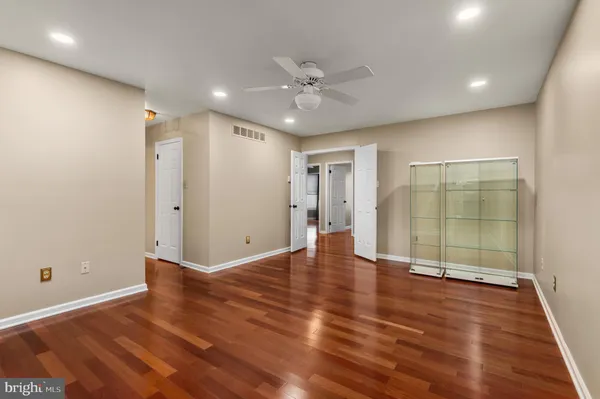 an empty room with wooden floor and mirror