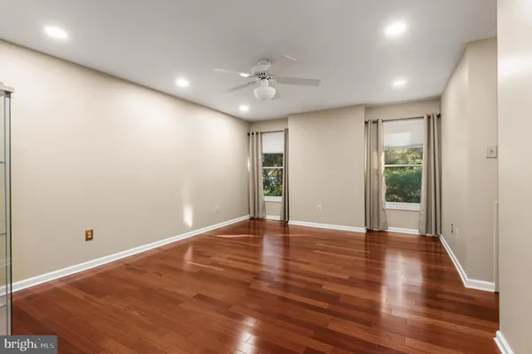 an empty room with wooden floor and windows