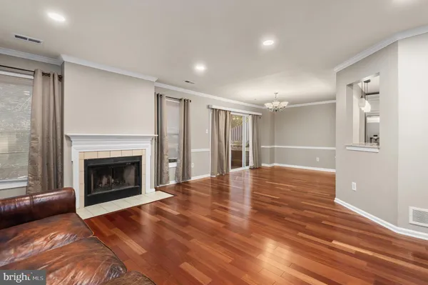 a view of a livingroom with wooden floor and a fireplace