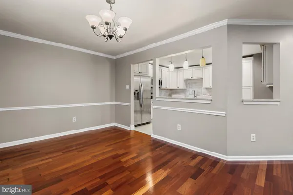 a view of a room with wooden floor and a ceiling fan